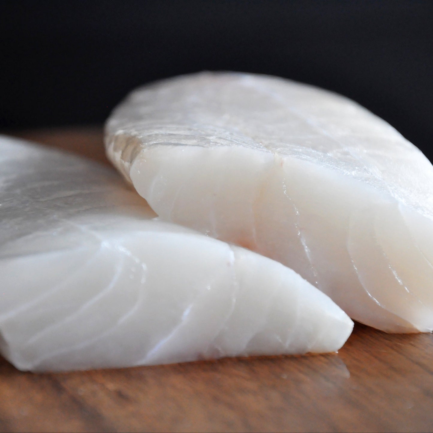 Close up of raw cod on top of a wooden board